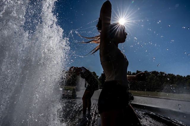 Temperaturen von ann&auml;hernd 40 Gra...tzen einen Brunnen zur Abk&uuml;hlung.  | Foto: Michael Kappeler/dpa