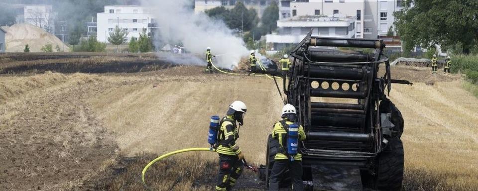 Rundballenpresse brennt auf Getreidefeld: Feuerwehr verhindert Ausbreiten des Feuers