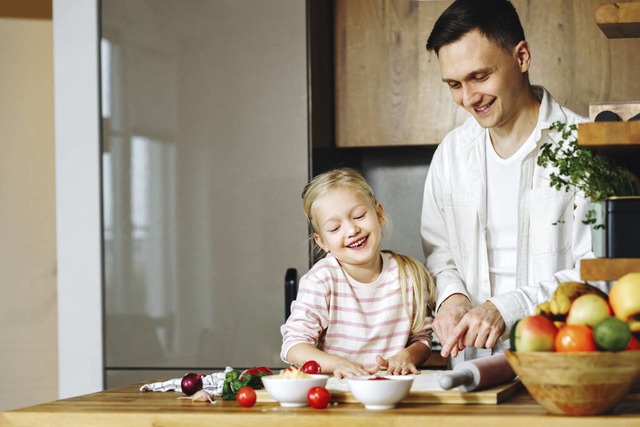 Ein Vater, der mit seiner Tochter koch... Eltern-Kind-Kochkurs in Gundelfingen.  | Foto: IMAGO/Natalia Shmatova