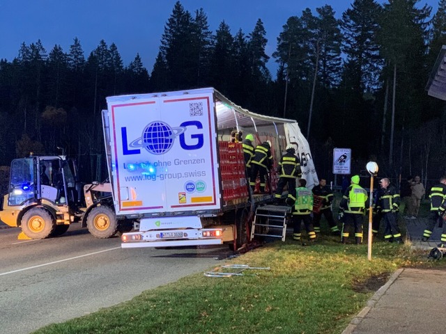 Ein Radlader sttzt die Ladung des Las...hrend die Feuerwehr die Kisten abldt.  | Foto: Benedikt Reder