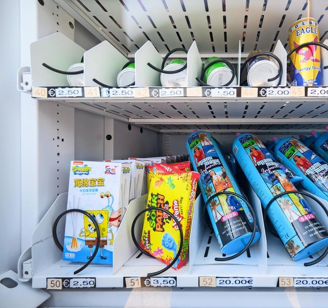 Ein Warenautomat, unter anderem mit La...stckt, steht vor einem Ladengeschft.  | Foto: Julian Stratenschulte/dpa