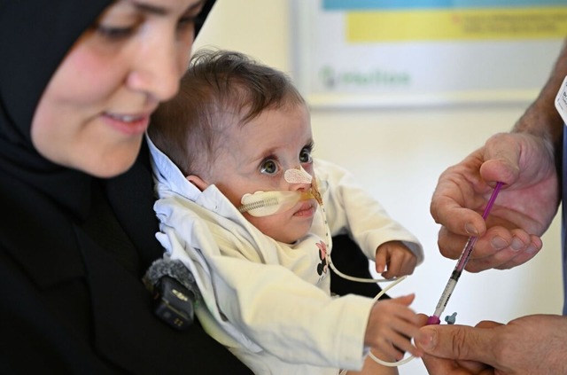 Sema wird bei einer Untersuchung im Kr...rer Mutter Sumeyra Kizilboga gehalten.  | Foto: Bernd Weibrod (dpa)