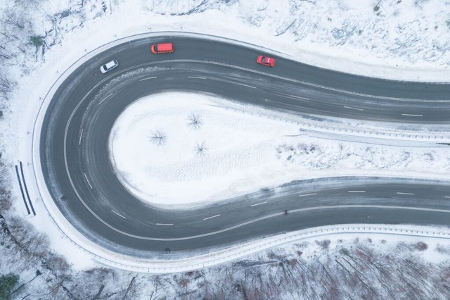 Autos fahren auf einer von Schnee gerumten Serpentine entlang.  | Foto: Sebastian Kahnert (dpa)