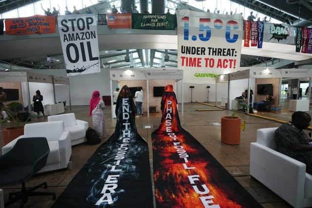 Aktivisten hngen Transparente auf, w...ion beim COP30-Klimagipfel teilnehmen.  | Foto: Andre Penner (dpa)