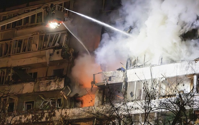 Feuerwehrleute lschen in der Nacht zu...e Wohnhuser nach russischem Beschuss.  | Foto: Efrem Lukatsky (dpa)