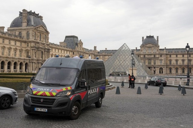 Ein Polizeiauto patrouilliert im Hof d...berfall geschlossenen Louvre-Museums.  | Foto: Thibault Camus (dpa)