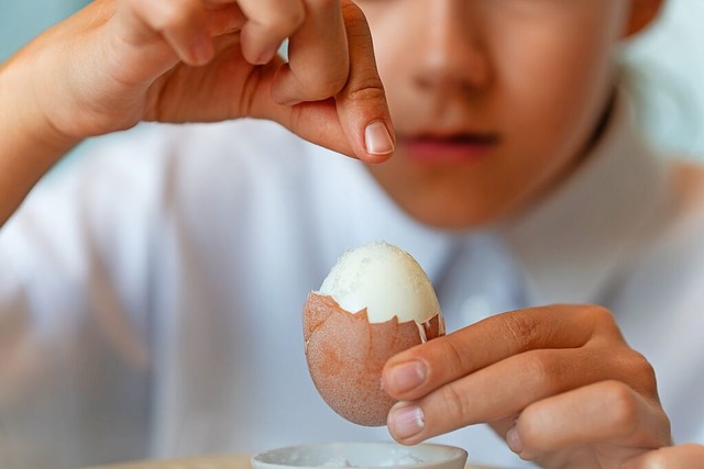 Ein Mdchen schlt ein hartgekochtes Ei &#8211; Nahaufnahme.  | Foto: diy13 (stock.adobe.com)