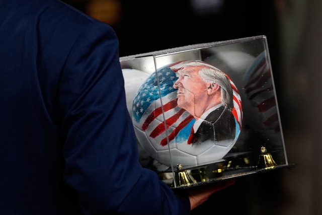 Vor der Auslosung ist auch ein Ball mit dem Gesicht von Trump zu sehen.  | Foto: Julia Demaree Nikhinson/AP/dpa