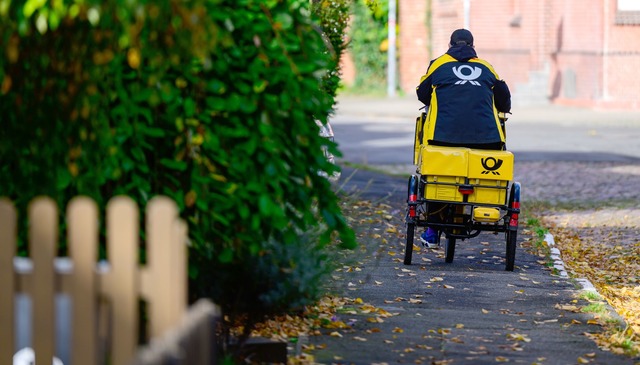 Ein Brieftr&auml;ger bei der Arbeit.  | Foto: Philipp Schulze/dpa